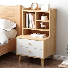 a small wooden book shelf next to a bed