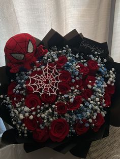 a bouquet of red roses and spider - man