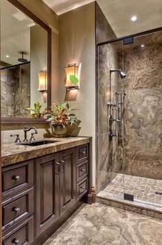 a bathroom with a walk in shower next to a double sink vanity and large mirror