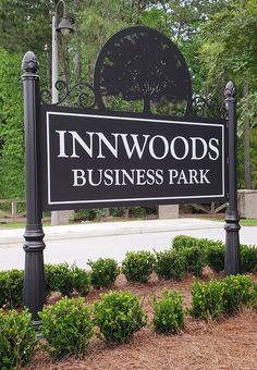 a sign for the innwoods business park in front of some bushes and trees