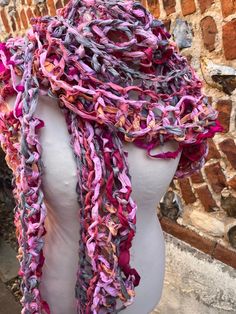 This is a hand knitted scarf from recycled sari silk ribbon. It is knitted loosely in a lovely loopy style, and is a mixture of pinks, peach, green, grey, lilac. It is incredibly long. Excluding fringes it is over 5 meters. The width is approx 27cms  A lovely floaty ethereal scarf that's soft against the skin.  Hand wash only at 30o. Dry flat. Pink Bohemian Scarf One Size, Pink Crochet Bohemian Scarves, Pink Crochet Bohemian Scarf, Bohemian Pink Crochet Scarves, Pink Bohemian Crochet Scarves, Bohemian Pink Crochet Scarf, Pink Hand Knitted Scarves One Size, Hand Knitted Scarf, Grey Lilac