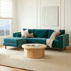 a living room with a blue couch and coffee table in front of a large window