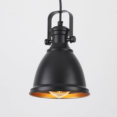 an industrial style pendant light with black metal finish and orange glass shade, hanging from the ceiling