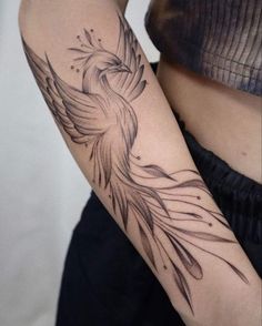 a woman's arm with a bird tattoo on the left side of her body