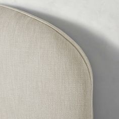 an upholstered headboard with white linen