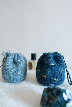 two small blue purses sitting on top of a white table next to each other