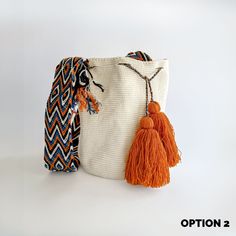 an orange tasselled bag with a white background