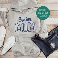 Calling all Senior Moms and Dads! Are you ready for Senior Night? Rep your kid this 2025 school year with your own customized hoodie or crewneck sweatshirt.  Fully customizable and expertly embroidered, this sweater makes an amazing gift for birthdays, holidays and graduation.   How to Order -  1. Pick your size and style. 2 Pick your shirt color. 3. In the personalization field, add your thread color, front personalization (Mom or Dad) and sleeve personalization (Name & Class Year). Limit 4 lin School Fan Apparel Cotton Sweatshirt, School Team Name Cotton Sweatshirt, School Spirit Hoodie With Letter Print, School Varsity Hooded Sweatshirt, School Spirit Winter Hoodie For School, Winter School Spirit Hoodie For School, School Spirit Hooded Hoodie, School Hoodie Sweatshirt With Letter Print, Letter Print Hoodie Sweatshirt For School