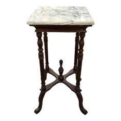 a marble top end table with wooden legs and an ornate design on the base, against a white background