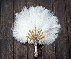 a white feather fan sitting on top of a wooden floor