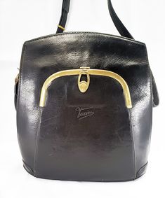 "Texier" brand, black genuine leather bag and bronzed metal accessories. Well finished and with an original shape, on the front it has a pocket with a metal opening and a hot-stamped brand. The interior is in honey-colored eco-leather and here too we find the label. On the back we also have a zip pocket. The bag is complete with the original adjustable shoulder strap. It presents very well, it is obviously a vintage object, but it does not show too many defects. Versatile and suitable for any ty Vintage Leather Bag, Sling Bags, Honey Colour, Bronze Metal, Vintage Bag, Metal Accessories, Genuine Leather Bags, The 70s, Vintage Shop