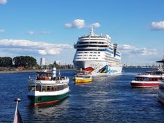 several boats in the water near a cruise ship