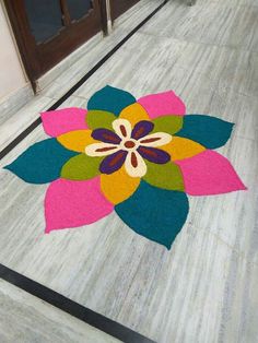 a colorful flower rug on the floor in front of a door