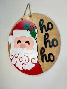 a wooden sign that says ho ho ho with a santa clause on it's face