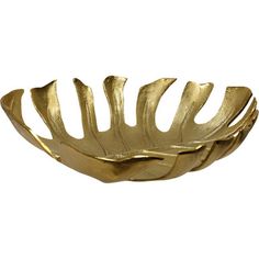 a gold leaf shaped bowl sitting on top of a white table