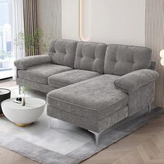 a living room with a gray couch and white rugs on the floor in front of a large window