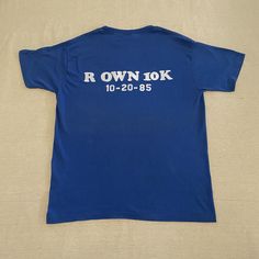 "Vintage '80s blue iron-on lettering graphic tee in great condition  - No tag but feels like a cotton blend to me-- super soft material - Iron-on lettering on the back - Pilling throughout & a small grease stain on the front, see photos & zoom in for details  Measurements (taken flat): - Pit to pit: 20\" - Top to bottom: 26 1/2\" **PLEASE NOTE** This is a vintage item, which means it is 20+ years old, which means a few things: 1) There will most likely be at least a little wear & tear! 2) Tag sizes will not be accurate!  3) Its production date is oftentimes approximate! ...I do my best to describe each item as accurately as possible, but please expect a human-like margin of error. All sales are final, so please reach out with any questions before you purchase!" Iron On Letters, Grease Stains, Ringer Tee, 20 Years Old, Grease, Soft Material, 20 Years, Graphic T Shirt, Vintage Items