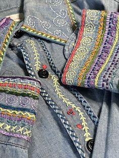 an old pair of jeans with colorful stitchs on them