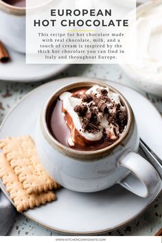 a cup of hot chocolate with marshmallows and graham crackers on the side