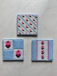 three pieces of woven fabric with pink and blue designs on them, sitting next to each other