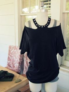 a mannequin wearing a black top with pearls on it