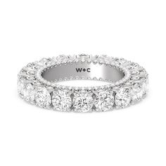 a white gold wedding band with five round diamonds on the side and an inscription, wlc