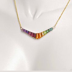 Discover our 18K Gold Rainbow V-Shaped Pendant Necklace, a striking fusion of vibrant hues and contemporary design that embodies diversity and self-expression. This pendant showcases a sleek V shape adorned with meticulously arranged multicolored gemstones, forming a captivating spectrum symbolizing unity within differences. Luxury Multicolor Multi-stone Necklaces, Luxury Multicolor Necklace With Gemstone Accents, Luxury Multicolor Necklaces With Gemstone Accents, Luxury Multicolor Gemstone Necklaces, Multicolor Necklaces With Gemstone Accents For Formal Occasions, Formal Multicolor Gemstone Necklaces, Luxury Multicolor Necklaces With Natural Stones, Modern Multicolor Jewelry With Stones, Luxury Multicolor Natural Stone Necklaces