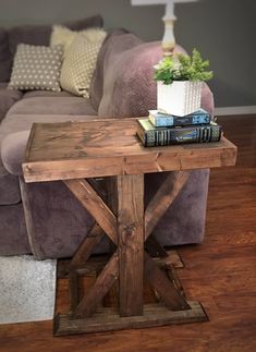 a wooden table sitting on top of a hard wood floor next to a purple couch