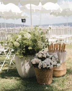 an outdoor ceremony setup with flowers and umbrellas