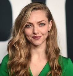 a woman with long blonde hair wearing a green dress