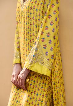 Editor's Note Embrace the allure of sunshine yellow with our mix print kurta, adorned with delicate hand-embroidery on the sleeves and neckline. The harmonious blend of prints exudes a lively charm, while the matching printed pants complete the ensemble. Effortless elegance and intricate details come together in this captivating outfit. Fabric: Dupion silk Color: Yellow Components: Kurta and pants Occasion: Festive Disclaimer: Product color may slightly vary due to photographic lighting sources Printed Suit With Embroidery, Raw Mango Kurta Set, Embroidery On Printed Fabric Kurti, Printed Suits Design, Printed Kurti Designs Style, Alia Cut, V Neck Kurta, Kurta And Pants, Yellow Kurti