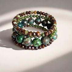 Shades of green, blue, and brown dominate this beaded coil wrap bracelet. Faceted chrysoprase, round jade, and African turquoise come together in a medley of tone and texture in this done-for-you stack. I love the earth tones and contrast of size, color, and texture in this one-of-a-kind bracelet. 4mm round jade 4x5mm faceted chrysoprase 10mm African turqouise one size fits most - best for small to medium wrists Handmade in Lincoln, Nebraska Turquoise Wrap Bracelet, Lincoln Nebraska, Love The Earth, African Turquoise, Blue And Brown, Earth Tones, Earring Necklace, Nebraska, Ring Necklace