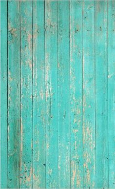 an old green wooden wall with peeling paint on the bottom and bottom part, as if it were painted in teal