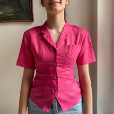 "Coming in hot we have this shocking pink vintage shirt that will make those workwear outfits pop. With stellar tailoring and gorgeous little brassy metal buttons, this fab pink shirt is a funky yet fabulous mix of 80s vintage vibes and victorian corset coquette edge 💘 Comes in recycled plastic free packaging ♻️ * Fits sizes UK4-8 depending on desired fit  * The model is 5'11\" and wears size UK8 * Pit to Pit - 19\" * Top to bottom - 23.5\"     SH-90" Cheap Vintage Short Sleeve Shirt With Button Closure, Pink Fitted Short Sleeve Shirt, Pink Collared Shirt With Buttons, Pink Fitted Collared Shirt, Fitted Pink Top With Button Closure, Pink Button-up Shirt, Pink Button-up Tops With Button Closure, Summer Retro Pink Blouse, Retro Pink Summer Blouse