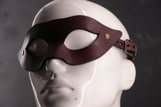 Deep, luxurious oxblood leather paired with warm bronze hardware makes this winged mask a show-stopping accessory. Perfect for standing out at any gathering, it radiates confidence and charisma. Sabersmyth's leather masks are a bold blend of artistry, comfort, and durability. Each mask is expertly shaped to fit the unique contours of your face, offering both a snug fit and lasting comfort. Spacious eye openings ensure clear peripheral vision and won't interfere with your makeup, while our signature head cradle design guarantees a secure, comfortable wear. Designed to make a statement and built to last, these masks will be the envy of every event. Peripheral Vision, Oxblood Leather, Costume Masks, Leather Mask, Bronze Hardware, Costume Mask, Makeup Yourself, Costume Accessories, Selling On Etsy