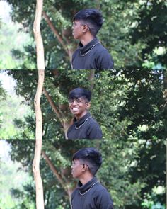 a man in black shirt standing next to trees