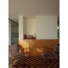 two chairs sitting on top of a checkered rug