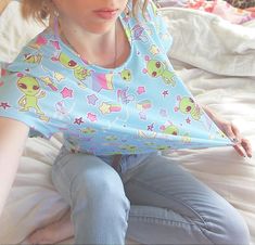 A pastel blue alien shirt featuring little green aliens who are only out to abduct your heart and bring a little shock of pastel to your life. This cropped t-shirt, which has a slightly silky, knit feel, also has contrasting rainbows and stars. It's unisex and fits loose, making for a comfy casual addition to your fairy kei and decora wardrobe while being low-key. Apparel and bedding ship separate from handmade items. Delivered in 2-4 weeks. The colors print more pastel than the items I make mys Light Blue Kawaii, Kawaii Fairy, Blue Alien, Yume Kawaii, Alien Shirt, Blue Fairy, Cropped Tube Top, Cropped Tee, Crop Tshirt