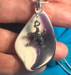 "This happy little pendant is made from a piece of quahog wampum found at Vonnegut Cove, Cape Cod, MA.  It's beautiful deep purple and crisp white colors are very striking.  I polished it to a high luster to bring out its natural beauty.  I added a cute Tibetan silver starfish charm that appears to be dancing on the purple wave.  The pendant (excluding bail) measures about 1 1/4\" by 1 3/4\". On a 24\" silver-plated snake chain with lobster clasp." White Star-shaped Ocean-inspired Jewelry, Ocean-inspired White Star-shaped Jewelry, Ocean-inspired White Star Jewelry, Handmade White Starfish Necklace, White Shell-shaped Jewelry With Starfish Charm, Cape Cod Ma, Aqua Beads, Woven Necklace, Blue Sea Glass