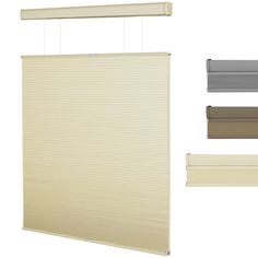 three different shades of blinds hanging from the ceiling and one is beige, white, gray