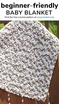 a crocheted baby blanket sitting on top of a wooden fence with the text, begin