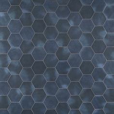 a black tiled wall with hexagonal tiles on the top and bottom, in shades of blue