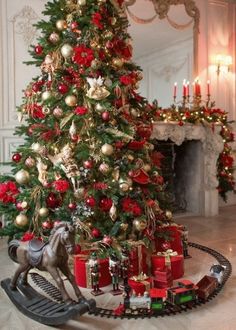 a christmas tree with presents under it and a toy horse on the ground next to it