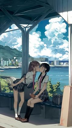 two people kissing each other in front of a window with the ocean and mountains behind them