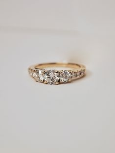 a three stone diamond ring sitting on top of a table