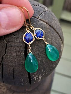 Lapis Lazuli and Green Onyx Earrings, Blue and Emerald Green Dangle Earrings, May Birthstone Drops in Gold, Gemstone Statement Jewelry Gift These rich and vibrant color earrings feature Lapis Lazuli free form gemstones bezeled in gold filled and suspended from them are flawless quality micro faceted green onyx teardrops wire wrapped in gold filled. The earrings come suspended from gold filled lever back ear wires. These earrings are colorful and are sure to make a statement, the navy and dark gr Sapphire Teardrop Jewelry With Gemstone Accents, Elegant May Birthstone Blue Jewelry, Blue Faceted Long Drop Jewelry, Blue Drop Earrings With Ethical Gemstones, Sapphire Drop Earrings With Matching Earrings, Blue Dangle Jewelry With Gemstone Accents, Faceted May Birthstone Drop Earrings, May Birthstone Faceted Drop Earrings, Sapphire Dangle Jewelry With Matching Earrings