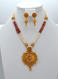 This beautiful antique gold pendant features Kemp stones and American diamonds, paired with a Pearl Mala Necklace and earrings set. This exquisite necklace enhances your style for any occasion, adding sparkle whether you wear it with a dress or a stunning saree. Necklace Length: 11.5" and can be adjusted with a chain. Earring length: 1.5" with push-back closure Antique gold Polish and High-quality brass as the base metal Availability: In-Stock. *Color may vary slightly due to light condition & p Elegant 22k Gold Jewelry Sets For Puja, Elegant Dual-tone Temple Necklace For Puja, Elegant Dual-tone Necklace For Puja, Elegant Hand Set Jewelry For Puja, Bollywood Style Gold Necklace With Matching Earrings, Gold Cutdana Necklaces For Anniversary, Gold Cutdana Necklace For Anniversary, Gold Necklace With Cutdana For Anniversary, Traditional Pendant Jewelry Sets For Anniversary