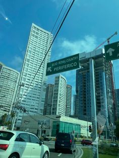 cars are driving down the street in front of some tall buildings and traffic signs with arrows pointing to different directions