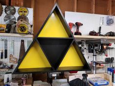 a yellow and black triangle shaped lamp sitting on top of a workbench in a garage