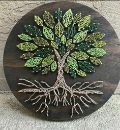 a wooden plaque with a tree on it's side and roots in the center